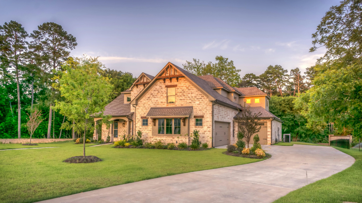 A house with beautiful lawn and trees surrounding it